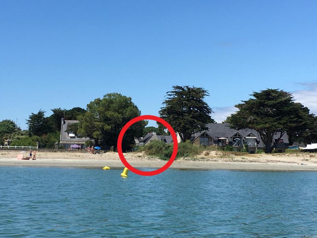 un objet rouge dans l'eau à côté d'une plage dans l'établissement Maison Sarzeau, 8 pièces, 12 personnes - FR-1-639-18, à Sarzeau