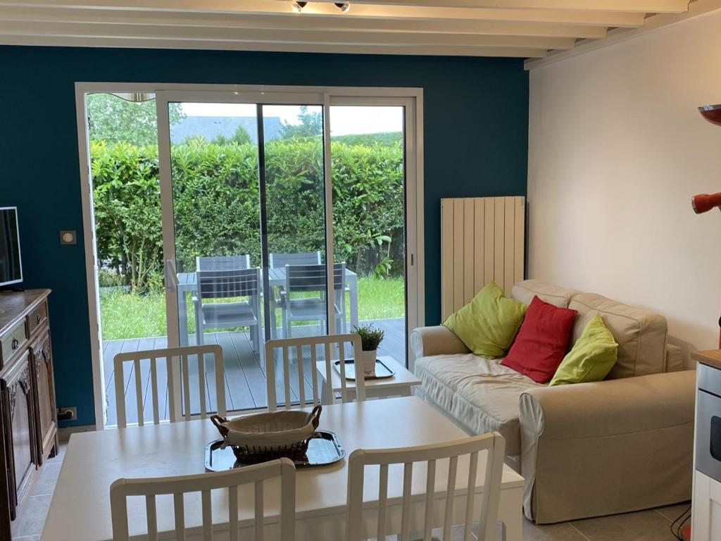 un salon avec un canapé et une table dans l'établissement Charmant Cottage 2P avec Jardin et WIFI, à 2 Pas de la Plage de Cabourg - FR-1-487-285, à Cabourg