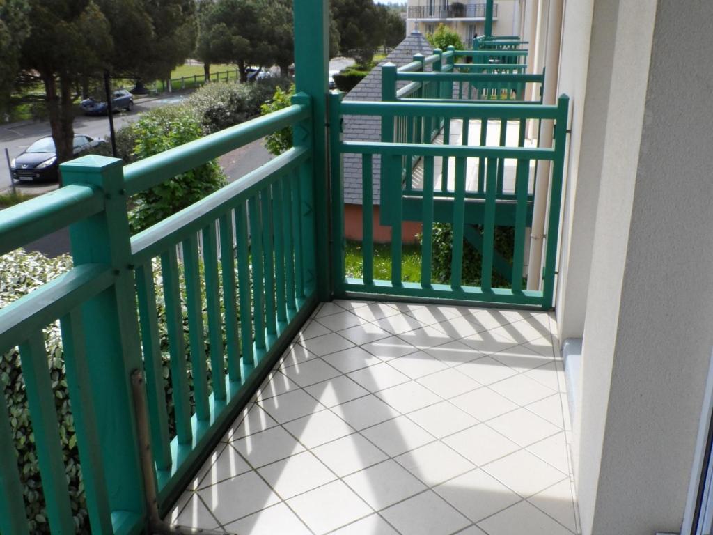 a balcony with green railings on a building at Appartement Dives-sur-Mer, 2 pièces, 4 personnes - FR-1-487-294 in Dives-sur-Mer