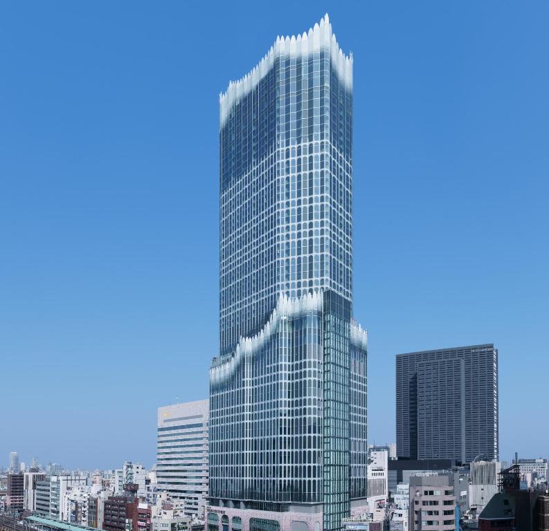 a tall glass building in a city at HOTEL GROOVE SHINJUKU, A PARKROYAL Hotel in Tokyo