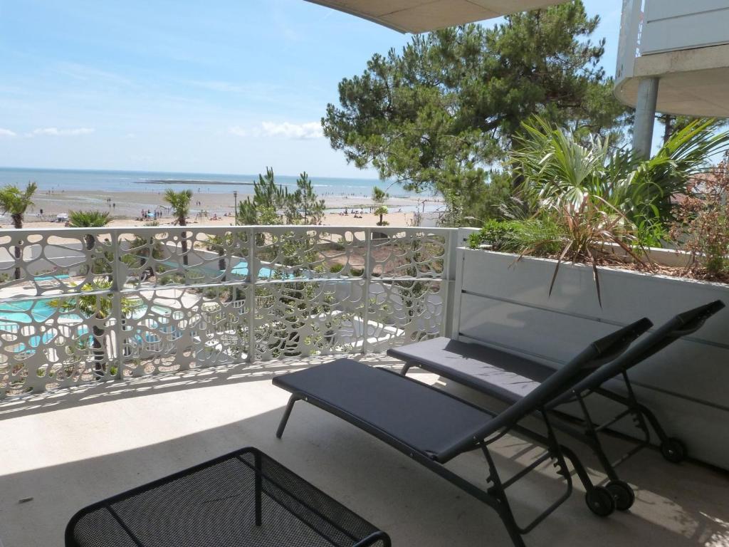 a chair on a balcony with a view of the beach at Appartement luxe 2 chambres, balcon, accès plage, piscine, animaux admis, parking - FR-1-194-236 in La Tranche-sur-Mer