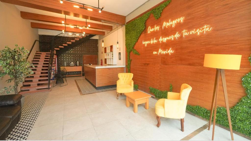 a lobby with yellow chairs and a table and stairs at HIT Merida Hotel Boutique in M&eacute;rida