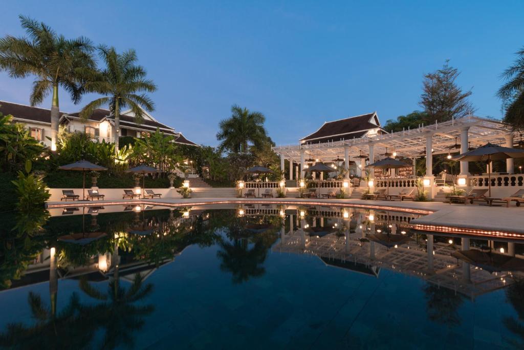 a resort with a swimming pool at night at The Luang Say Residence in Luang Prabang