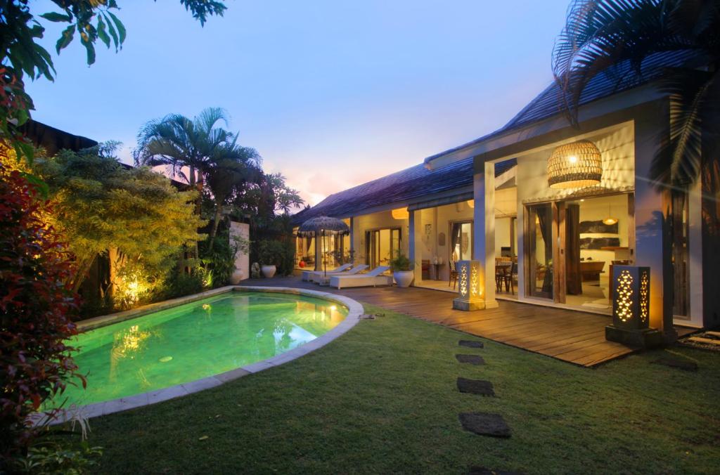 a house with a swimming pool next to a house at Villa Ananda by Optimum Bali Villas in Seminyak