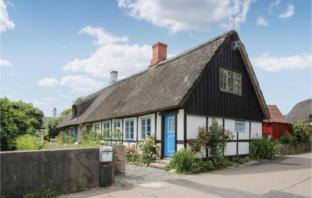 an old house with a thatched roof and a blue door at Stunning Home In Sams With Wifi in Nordby