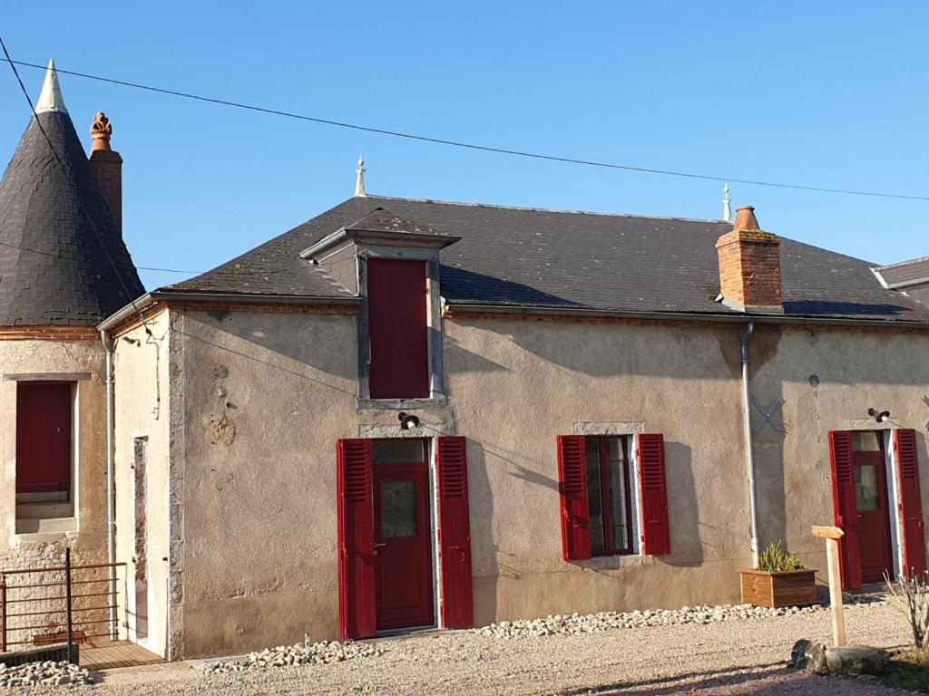 uma casa antiga com janelas vermelhas e um telhado em Gîte Cindré, 5 pièces, 10 personnes - FR-1-489-406 em Cindré