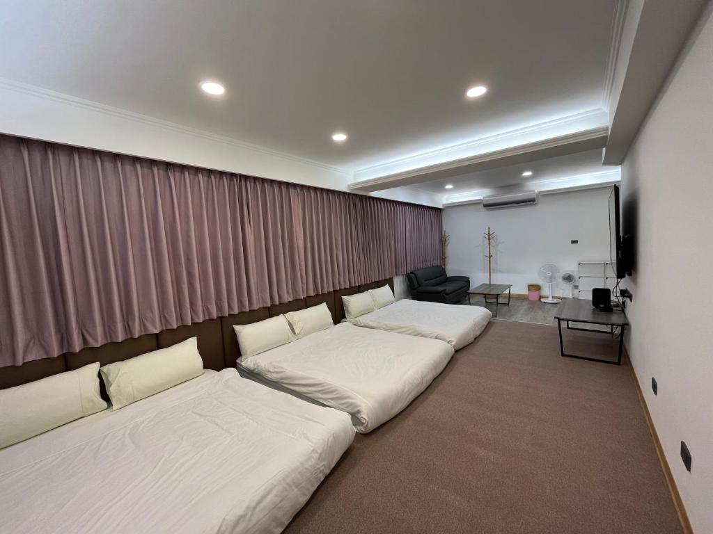 Tamshui Homestay في تامسوي: غرفة نوم بسريرين في غرفة