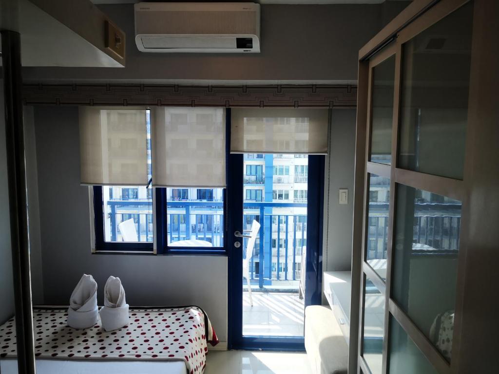 Pokój z łóżkiem z dwoma białymi butami w obiekcie Bliss by John at Sea Residences w mieście Manila