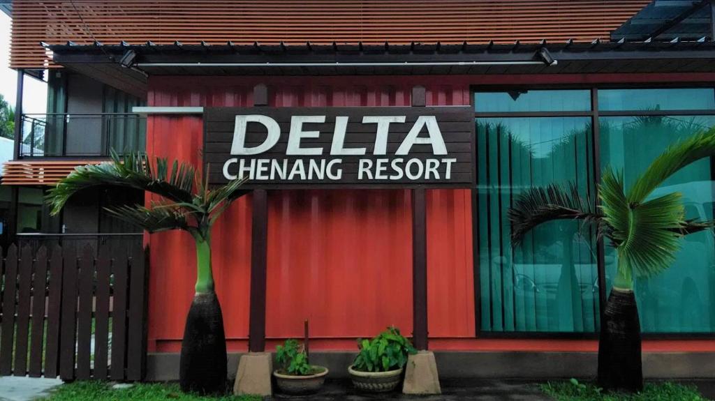 un bâtiment rouge avec un panneau indiquant le changement du delta dans l'établissement Delta Chenang Resort, à Pantai Cenang