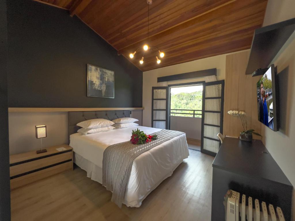 - une chambre avec un lit fleuri dans l'établissement Pousada Terrazzo Bonjardim, à Campos do Jordão