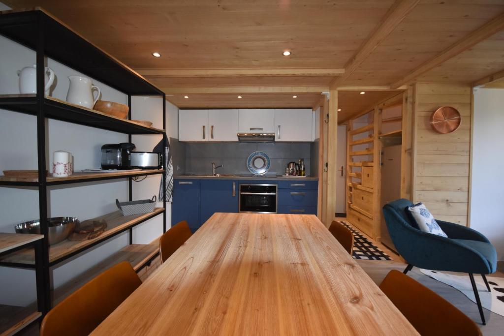 ein Esszimmer mit einem Holztisch und einer Küche in der Unterkunft Résidence Grand Roc - Campanules 308 - Happy Rentals in Chamonix-Mont-Blanc