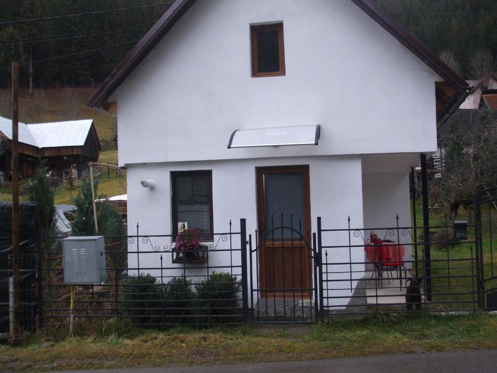 una casa blanca con una valla delante en Tiny house Floare de colt en Moieciu de Sus