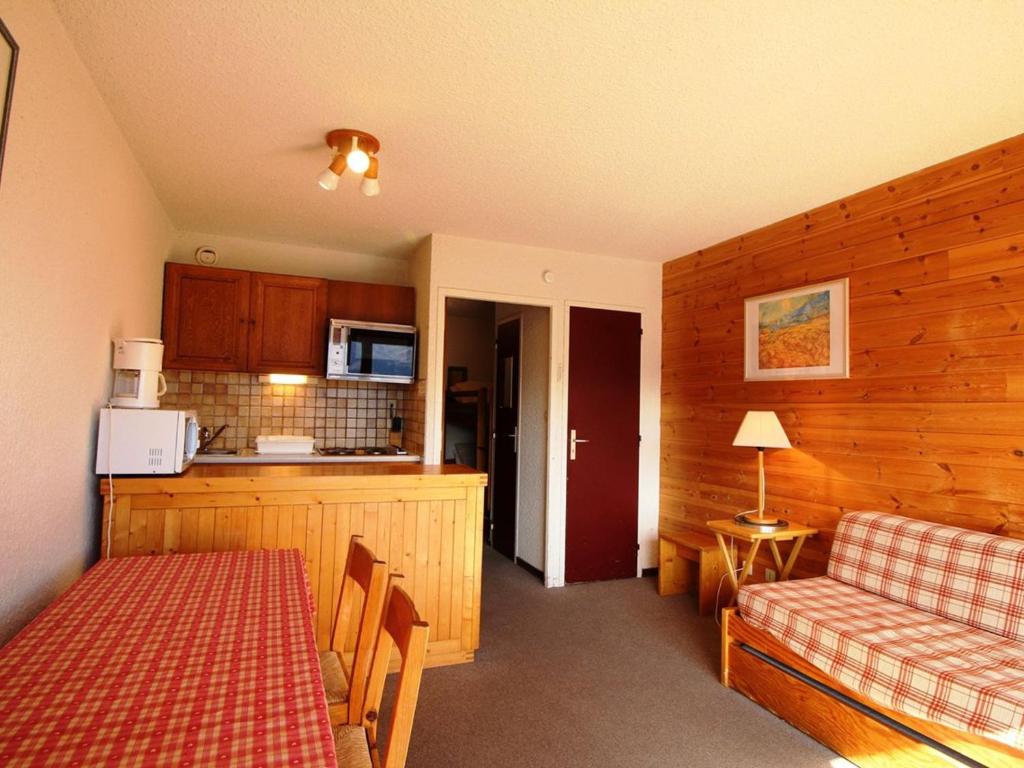 Cette chambre comprend une cuisine, une table et un canapé. dans l'établissement Studio cabine 4 pers, pieds des pistes, proche commerces, balcon, vue sur montagnes - FR-1-297-30, à Auris