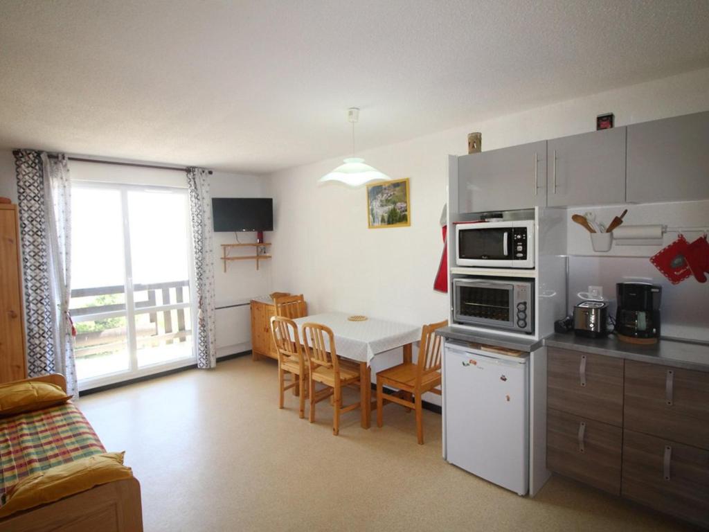 a kitchen and dining room with a table and a kitchen and a room at Appartement Auris, 1 pièce, 4 personnes - FR-1-297-61 in Auris