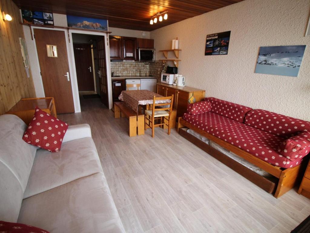 a living room with a red couch and a kitchen at Appartement Auris, 1 pièce, 4 personnes - FR-1-297-68 in Auris