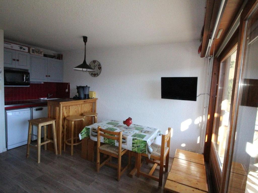 a small kitchen with a table and chairs in a room at Appartement Auris, 1 pièce, 4 personnes - FR-1-297-151 in Auris