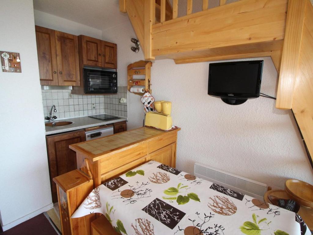een kleine keuken met een tafel en een televisie bij Appartement Auris, 1 pièce, 4 personnes - FR-1-297-158 in Auris