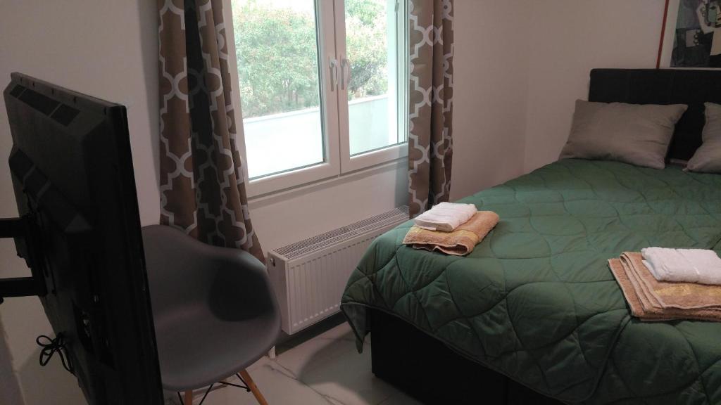 una camera con letto, televisore e finestra di New!90sqm10minAirport2bedrooms a Salonicco
