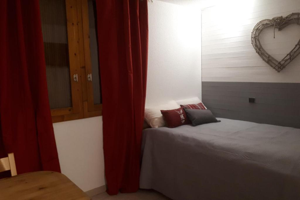 sypialnia z łóżkiem i sercem na ścianie w obiekcie Studio Near The Slopes At La Plagne w mieście La Plagne Tarentaise