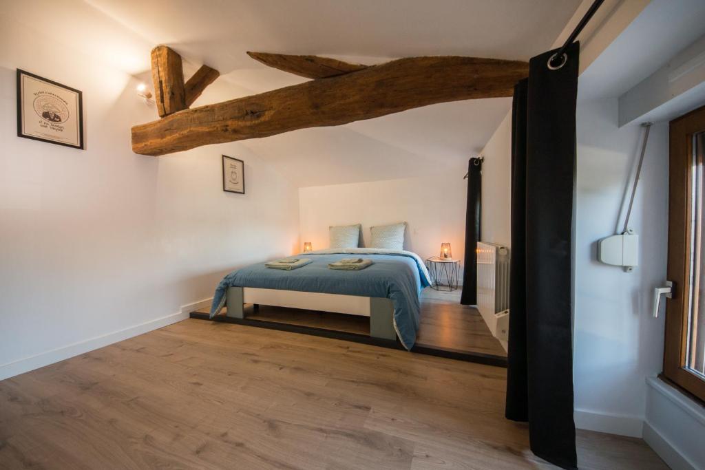 a bedroom with a bed and a wooden floor at La maison à Mimine in Le Pin-en-Mauges