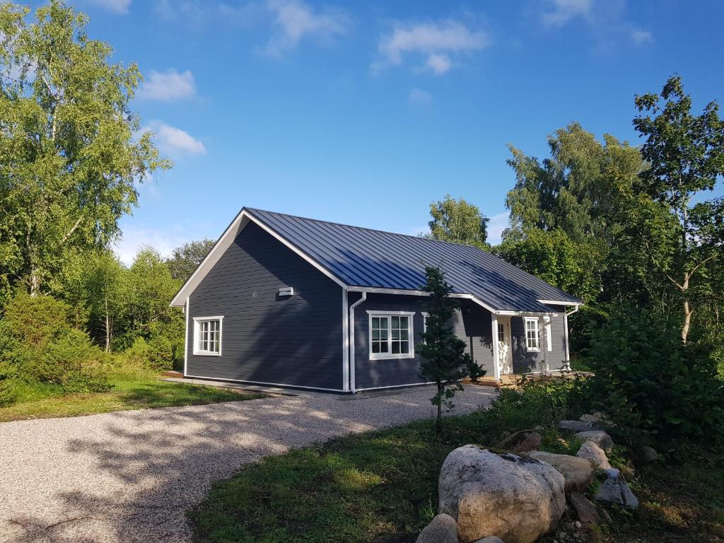ein Haus mit einem Sonnendach auf einer Auffahrt in der Unterkunft Kopli puhkemaja Saaremaal in Kasti