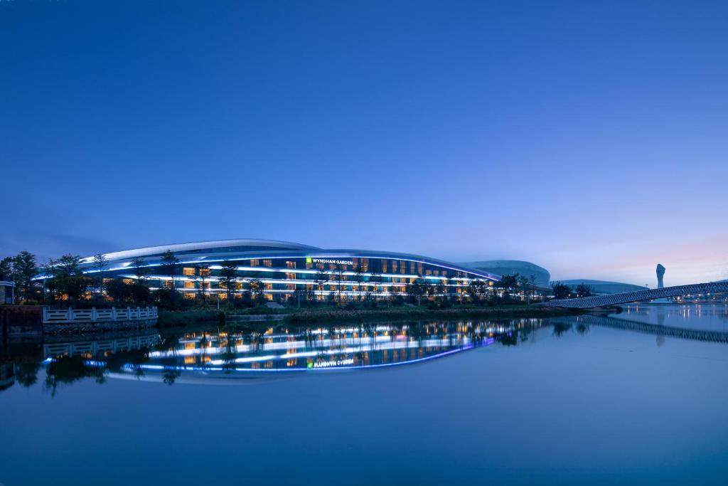 ein großes Gebäude an der Seite eines Wasserkörpers in der Unterkunft Wyndham Garden Jinjiang in Jinjiang