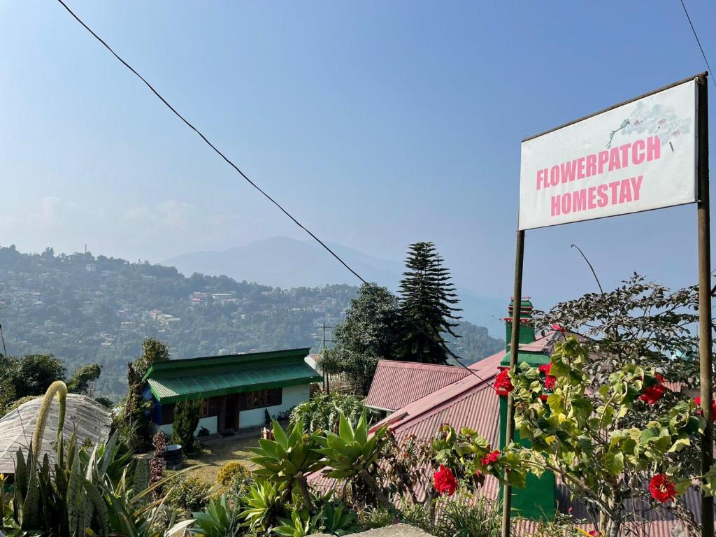 una señal frente a un edificio con una montaña en Flower Patch Homestay en Kalimpong