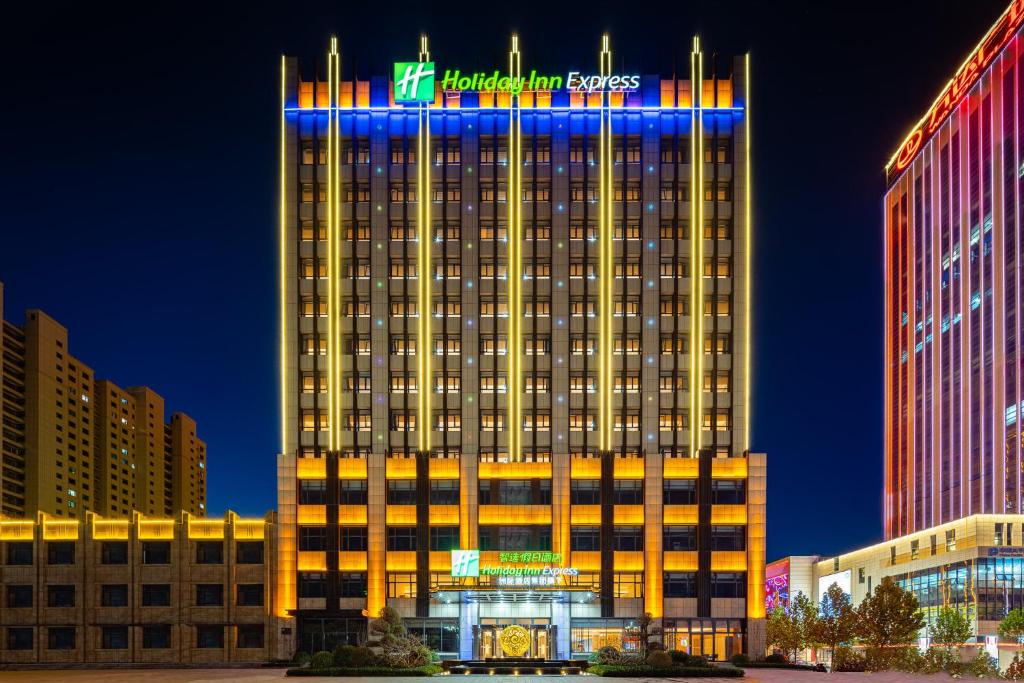 Holiday Inn Express Xinji City Center, an IHG Hotel في Xinji: مبنى فندق مضاء عليه لافته
