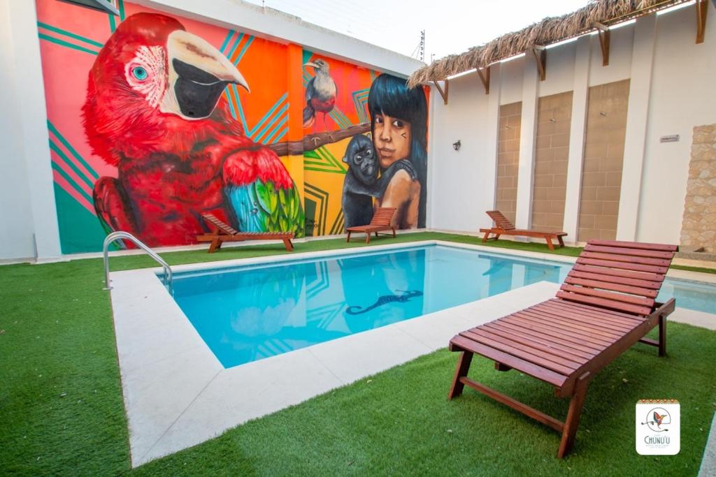 a mural of a parrot next to a swimming pool at Hotel Boutique CASA CHUNUU Santa Marta in Santa Marta