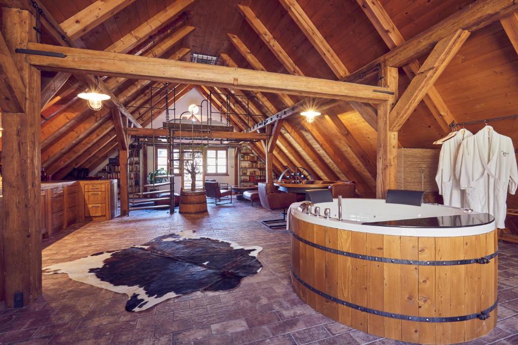 a large room with a tub in a wooden building at Mill Apartments in Český Krumlov