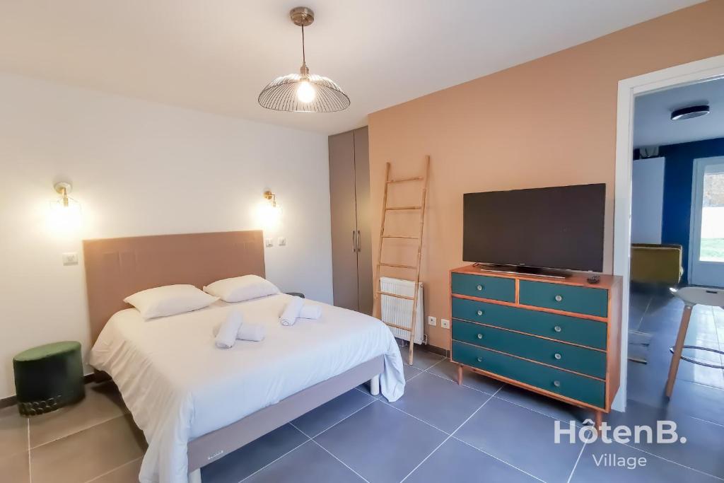 1 dormitorio con 1 cama y TV de pantalla plana en Les Myrtilles - Maison 6 personnes à Limoges en Limoges