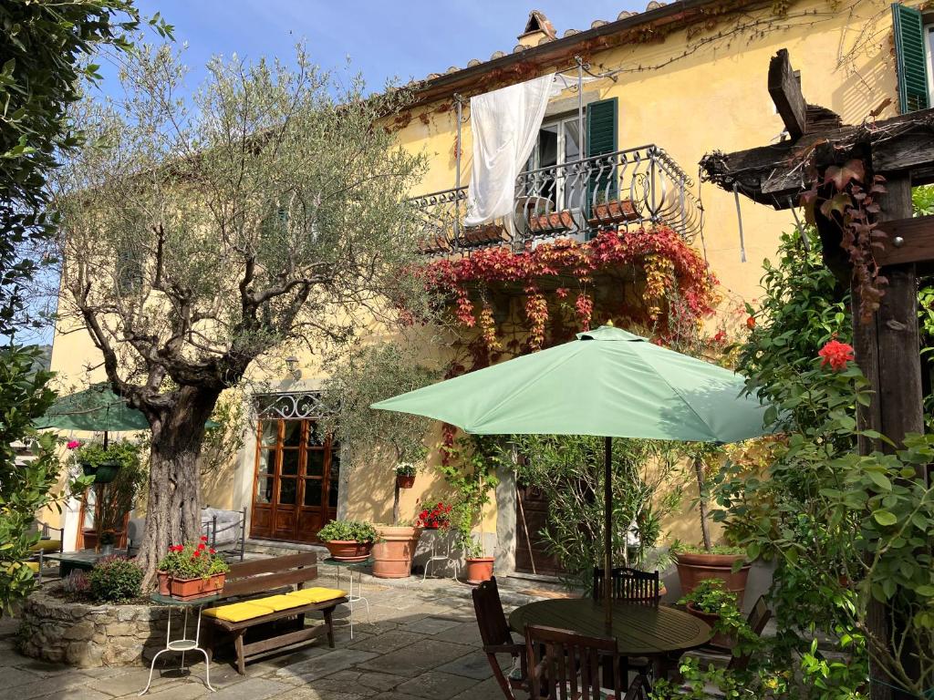 einem Tisch mit einem Regenschirm vor einem Gebäude in der Unterkunft Delizioso E Particolare Casale Con Piscina,cortona in Cortona