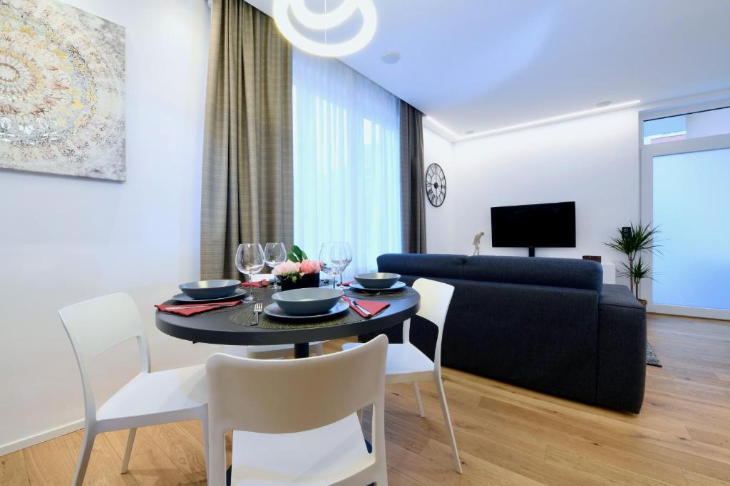a dining room and living room with a table and chairs at Lake Modern Suites - Free Parking in Lugano