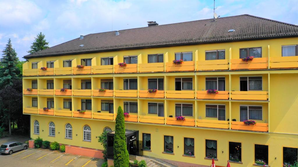 un edificio amarillo con flores en los balcones en Hotel Bayerischer Hof en Bad Kissingen