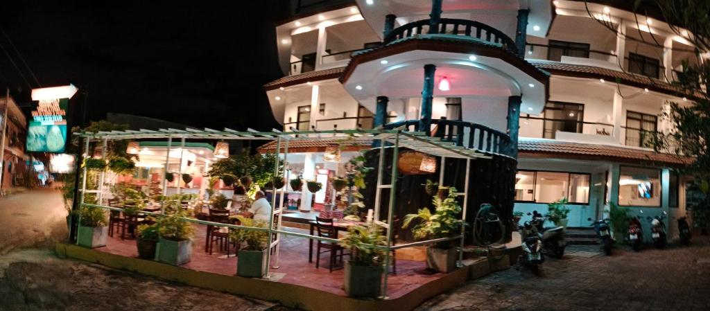 a restaurant with potted plants in front of a building at La Capannina Hotel Patong in Patong Beach
