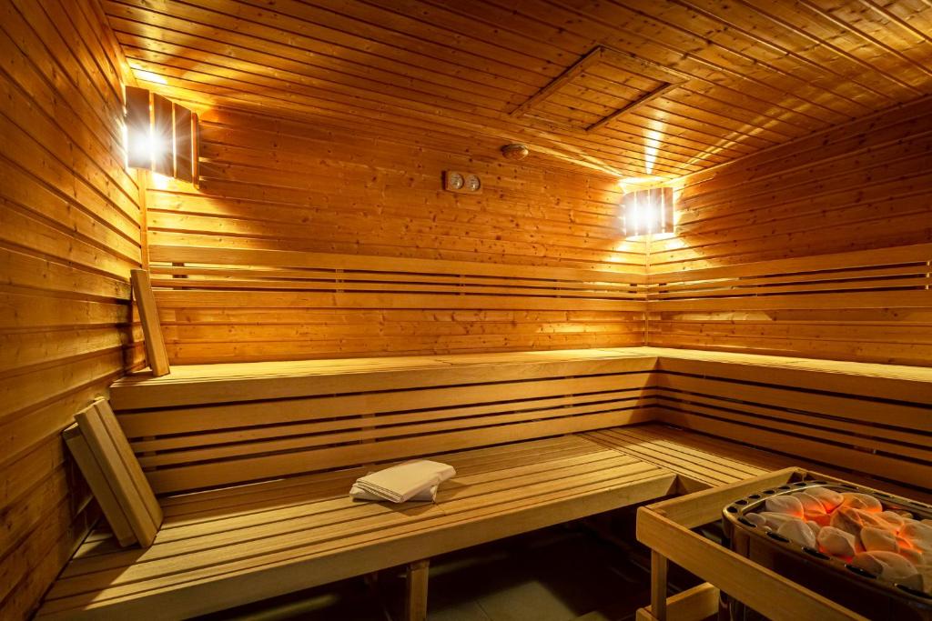 a wooden sauna with a bench and a table in it at Hotel Thermal in Karlovy Vary