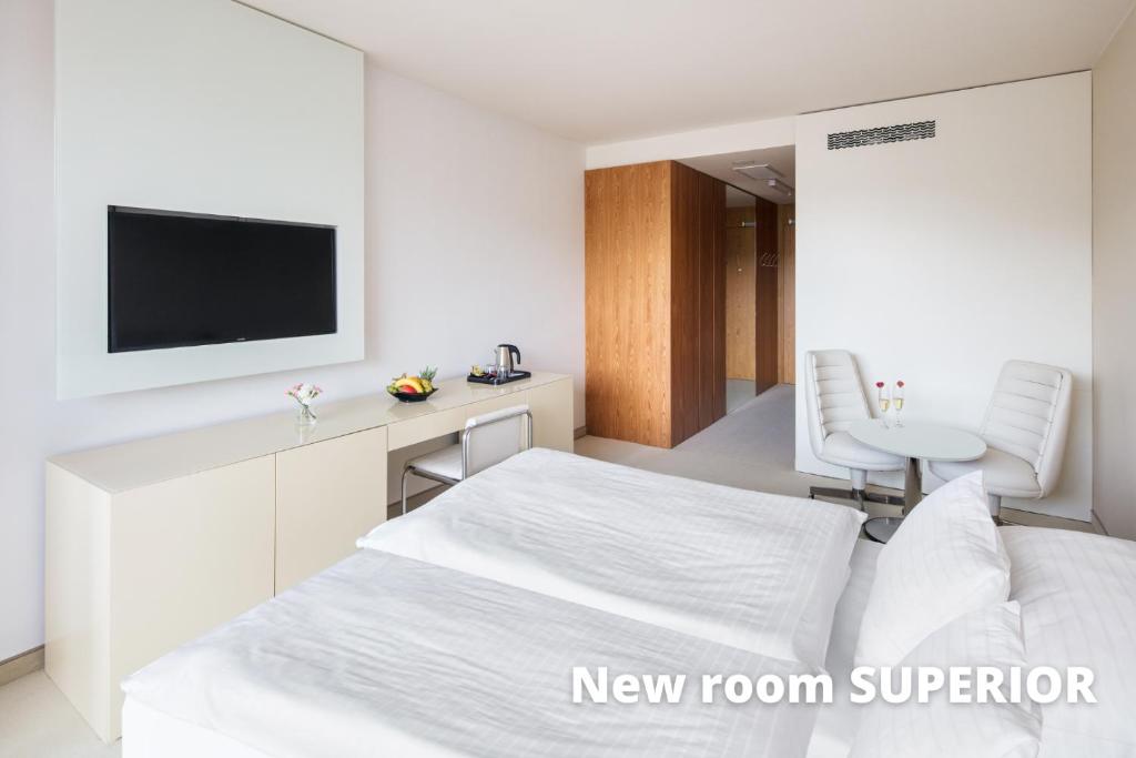 a white room with a bed and a television at Hotel Thermal in Karlovy Vary