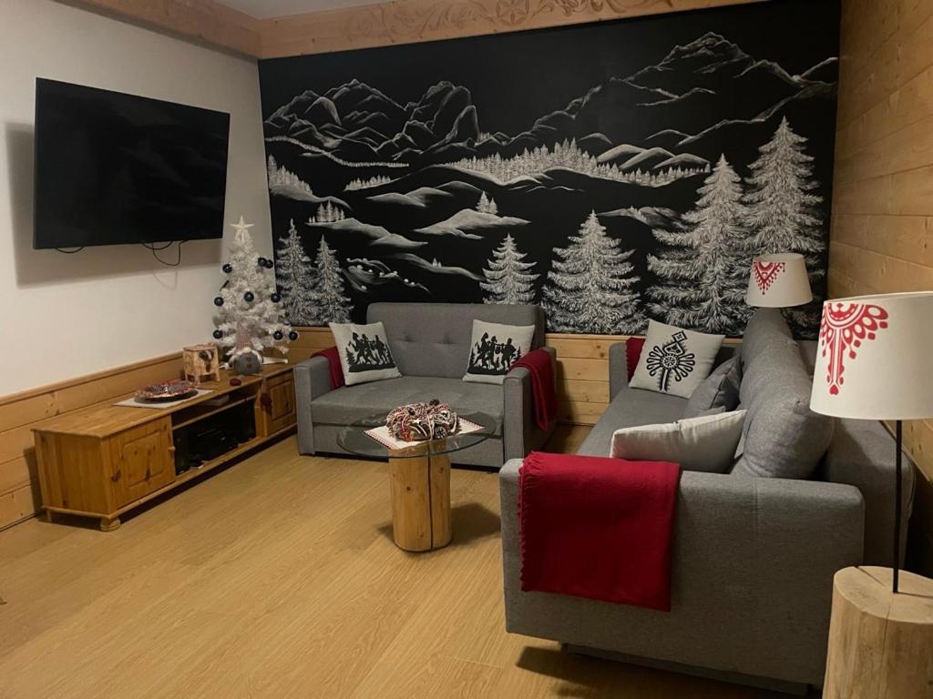 a living room with a couch and a tv at Apartament w Jaworkach - Pod Wysoką in Szczawnica
