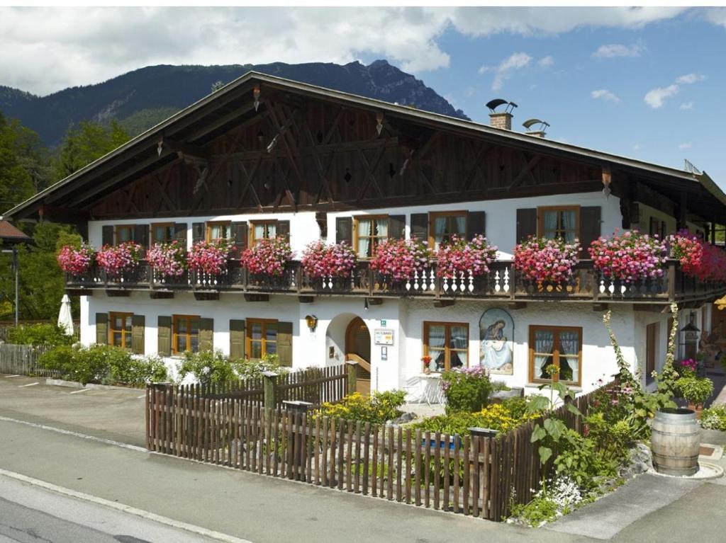 a white building with flowers on the balcony at Haus Huis'n in Grainau