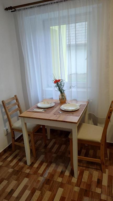 メディアシュにあるBabesh Central Apartmentの木製テーブル(2皿、椅子2脚付)