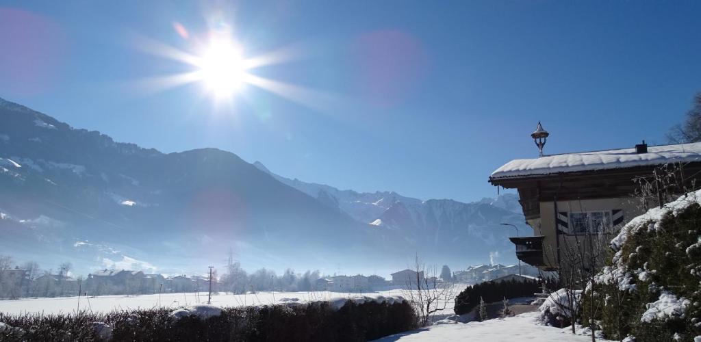 a sun shining in the sky over a snow covered mountain at Appart Tirol in Hippach