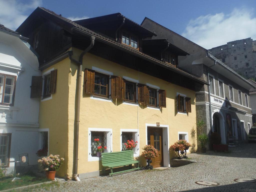 een geel gebouw met een groene bank ervoor bij Ferienwohnung Weberlenz in Gmünd in Kärnten