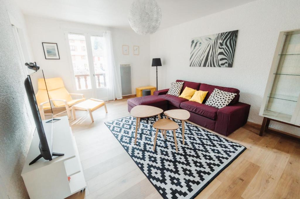 - un salon avec un canapé violet et un tapis dans l'établissement L'Enfantous, à Ax-les-Thermes