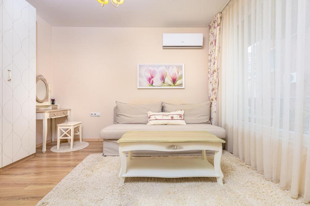 a small bedroom with a bed and a table at Bright & Cozy 1BD Flat with a Terrace and Parking in Plovdiv