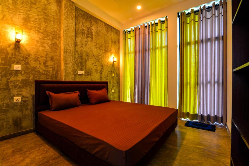 um quarto com uma cama com cortinas verdes em 2b1 weligama em Weligama