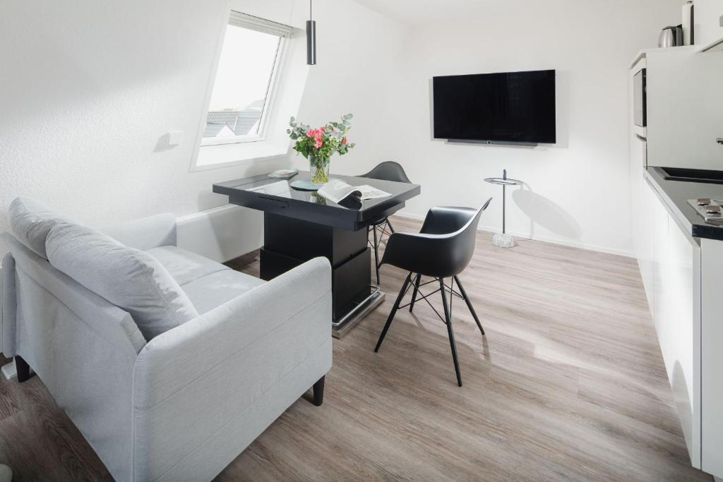 - un salon blanc avec un bureau et une chaise dans l'établissement Luisensuite, à Norderney