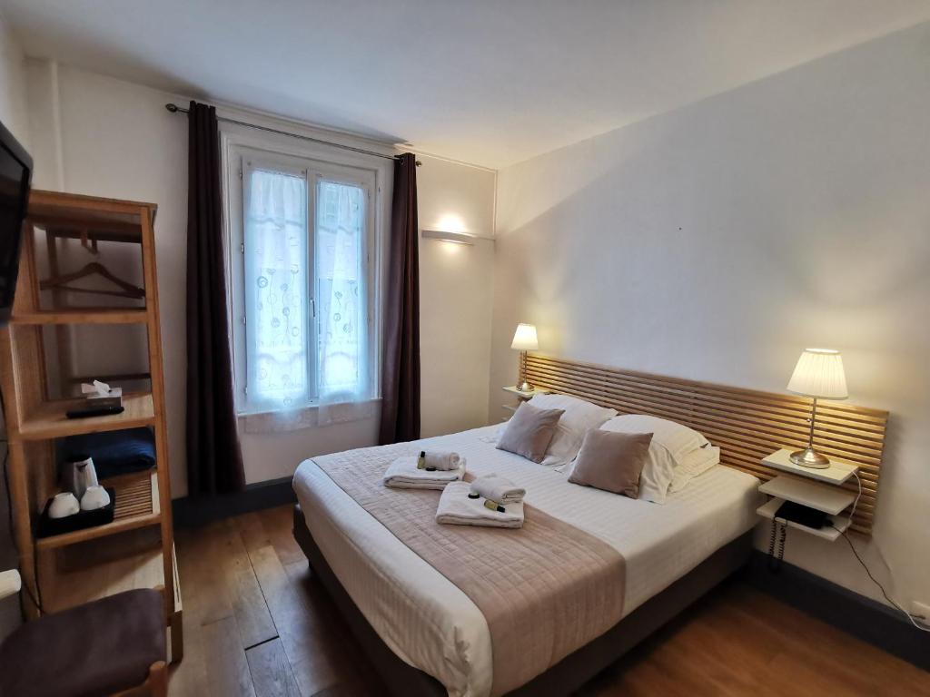 a bedroom with a bed with two towels on it at Hotel Des Falaises in Étretat