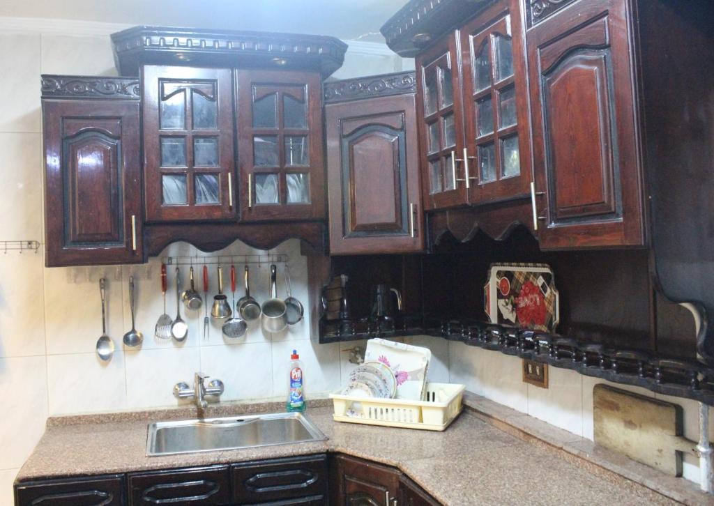 a kitchen with wooden cabinets and a sink at شقق فاخرة للايجار مفروش مصر الجديدة مساكن الشيراتون in Cairo