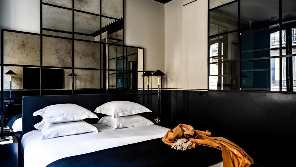 a bedroom with a large bed with white pillows at Monsieur George Hotel & Spa - Champs-Elysées in Paris