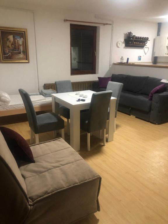 a living room with a table and chairs and a couch at Apartman Petrovic- 300m od gondole in Brzeće